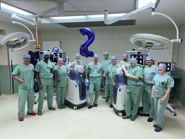 Zweiter Mako OP-Roboter im CKS PD Dr. Klotz und sein Team mit den beiden OP-Robotern in einem OP-Saal des Christlichen Klinikums Soest